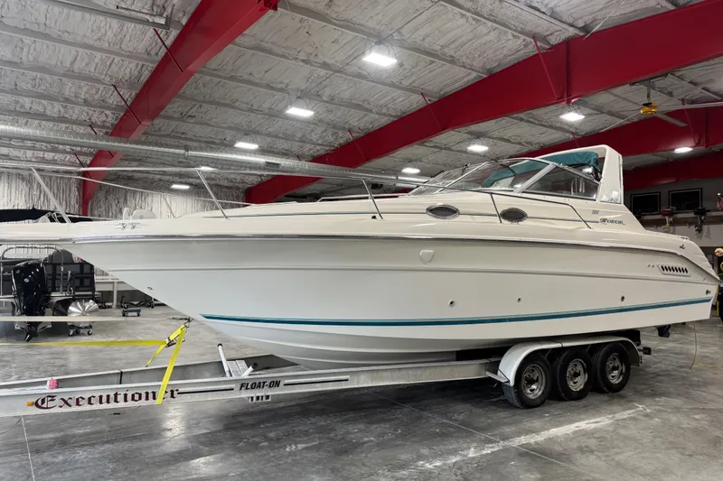 The Image of 1994 Sea Ray 300 Sundancer boat on trailer in indoor storage facility. - 1