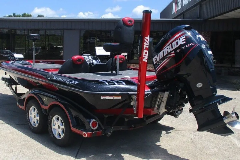 Slide: The Image of 2008 Ranger Z19 Comanche boat with Evinrude E-TEC engine, parked outdoors. - 2