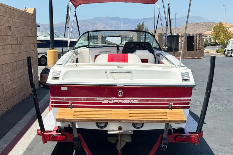 Slide: The Image of 1991 Ski Supreme MS Tournament Series boat with red and white design, parked outdoors. - 4