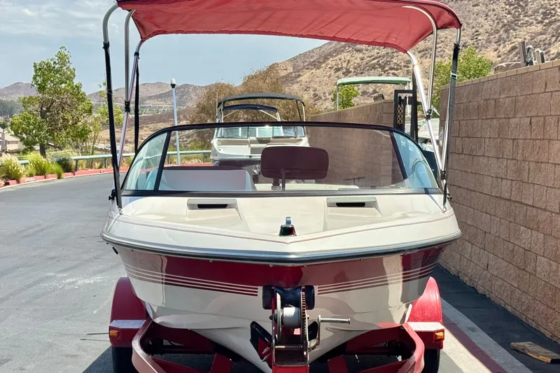 Slide: The Image of 1991 Ski Supreme MS Tournament Series boat with red canopy on trailer, parked outdoors. - 2