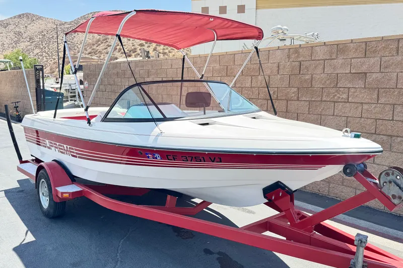 Slide: The Image of 1991 Ski Supreme MS Tournament Series boat with red canopy on trailer, parked outdoors. - 1