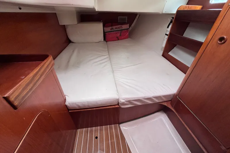 Slide: The Image of Cozy cabin interior of 1993 Beneteau Oceanis 400 sailboat with wooden finish and white cushions. - 25
