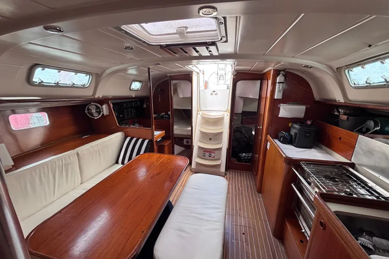 Slide: The Image of Interior of a 1993 Beneteau Oceanis 400 sailboat, featuring a cozy dining area and kitchen. - 31