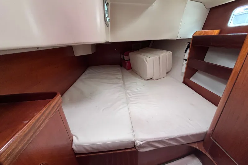 Slide: The Image of Interior cabin of 1993 Beneteau Oceanis 400 sailboat with wooden finish and white cushions. - 24