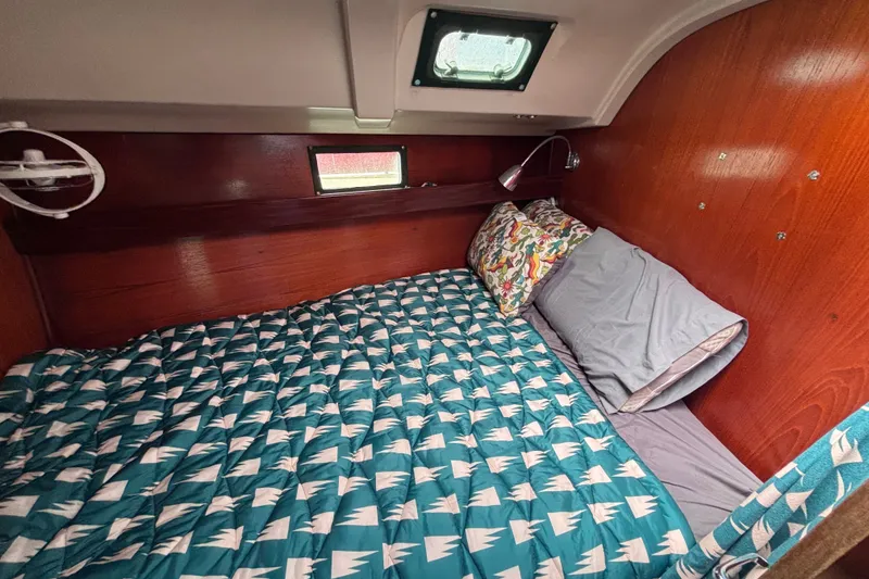 Slide: The Image of Cozy cabin interior of 1993 Beneteau Oceanis 400 sailboat with patterned bedding. - 34