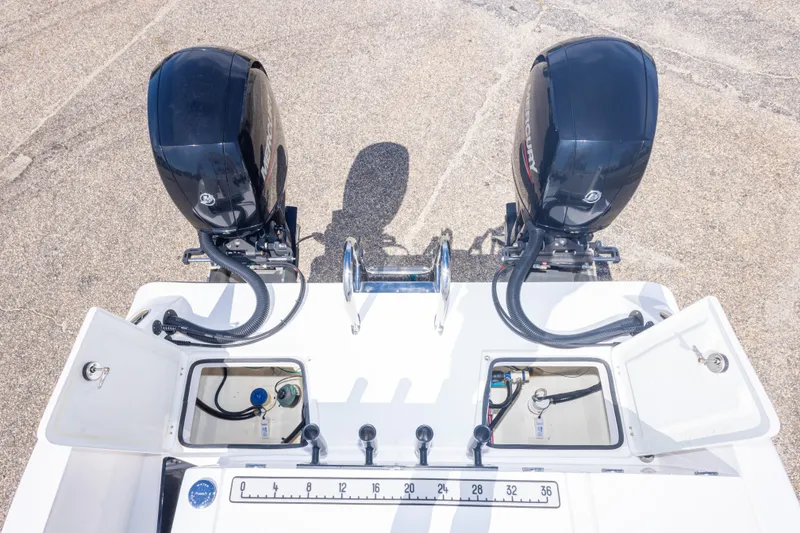 Slide: The Image of 2022 Twin Vee 240 GFX CC boat with dual Mercury outboard engines and open storage compartments. - 58