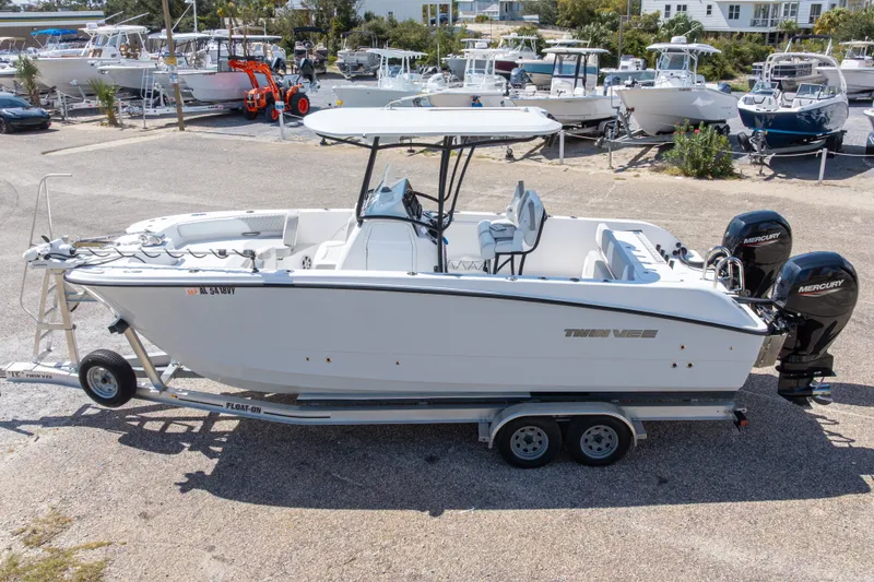 Slide: The Image of 2022 Twin Vee 240 GFX CC boat on trailer, featuring dual Mercury engines. - 13