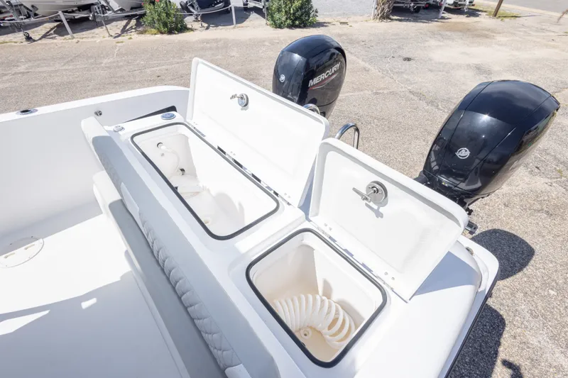 Slide: The Image of 2022 Twin Vee 240 GFX CC boat with open storage compartments and dual Mercury engines. - 56