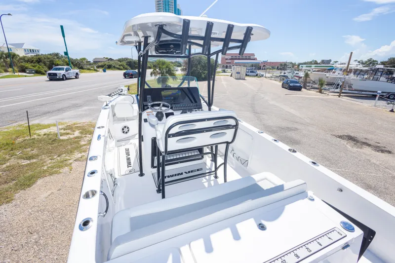 Slide: The Image of 2022 Twin Vee 240 GFX CC boat with sleek design, parked near a marina. - 27
