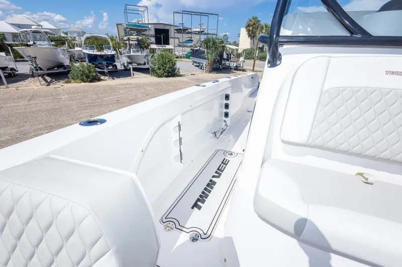 Slide: The Image of 2022 Twin Vee 240 GFX CC boat interior with white seating and logo. - 48