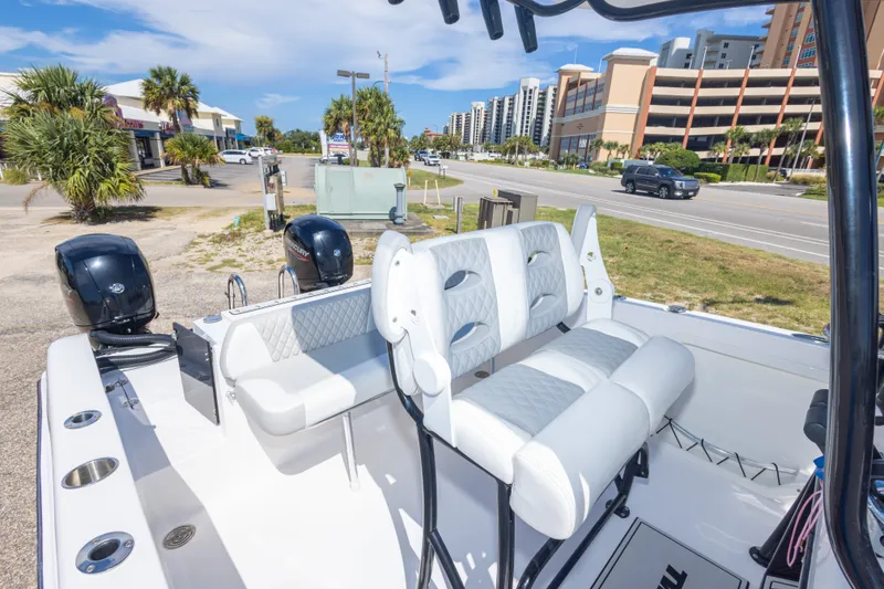 Slide: The Image of 2022 Twin Vee 240 GFX CC boat with dual engines, parked near a coastal road. - 52