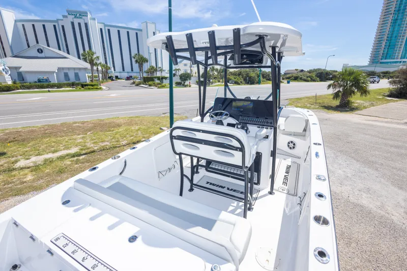 Slide: The Image of 2022 Twin Vee 240 GFX CC boat with modern console, parked near a coastal road. - 28