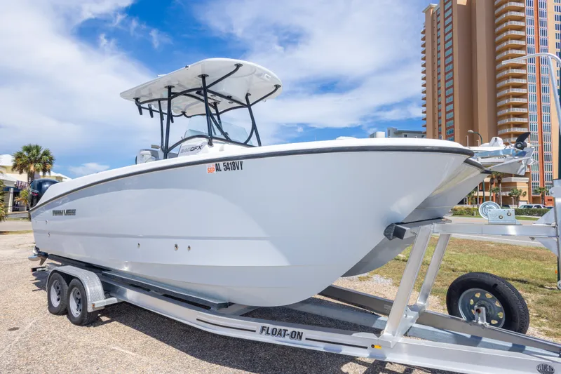 Slide: The Image of 2022 Twin Vee 240 GFX CC boat on trailer, parked near tall buildings. - 16