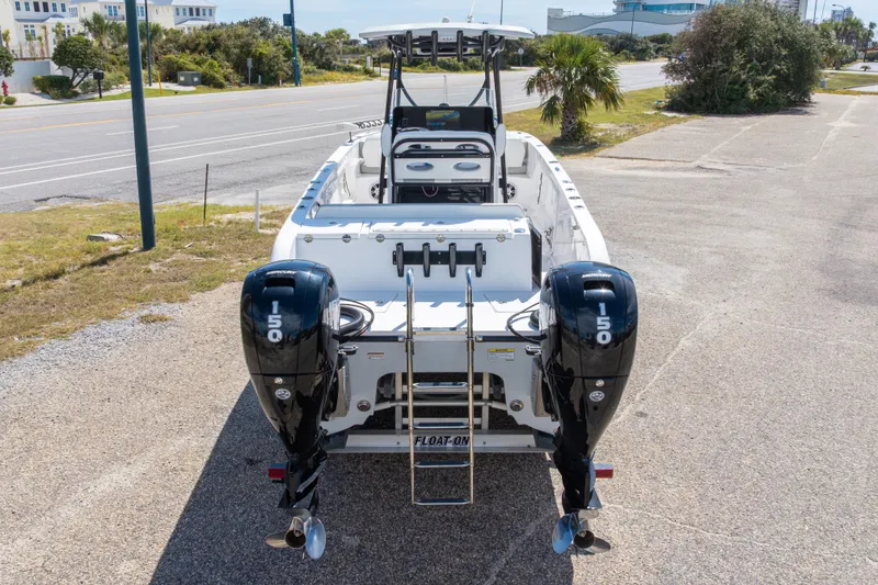 Slide: The Image of 2022 Twin Vee 240 GFX CC boat with dual Mercury 150 engines, parked on a sunny day. - 21