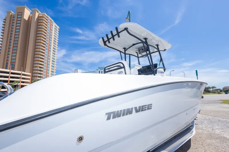 Slide: The Image of 2022 Twin Vee 240 GFX CC boat with cityscape background under clear blue sky. - 26