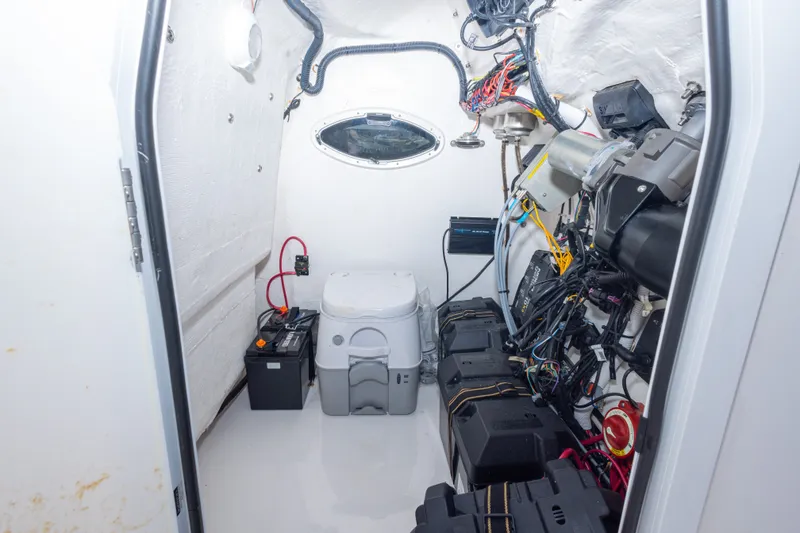 Slide: The Image of Interior of 2022 Twin Vee 240 GFX CC boat showing electrical components and portable toilet. - 37