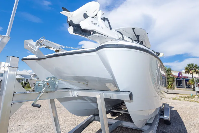 Slide: The Image of 2022 Twin Vee 240 GFX CC boat on trailer, featuring Garmin equipment, under a clear blue sky. - 23