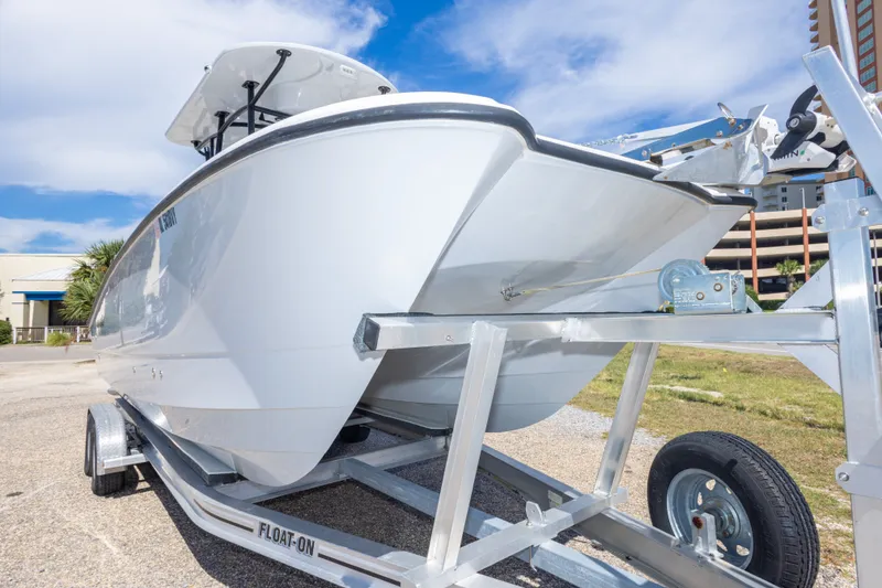 Slide: The Image of 2022 Twin Vee 240 GFX CC boat on trailer, parked outdoors under blue sky. - 24