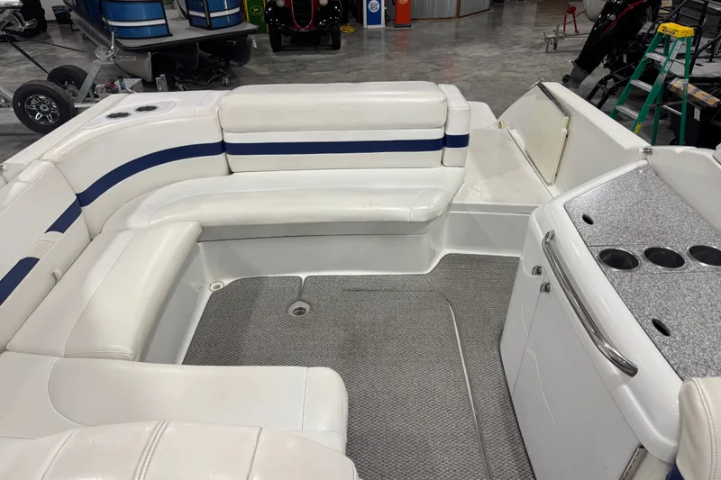 Slide: The Image of 2005 Formula 280 Bowrider interior with white seating and cup holders in a showroom. - 21