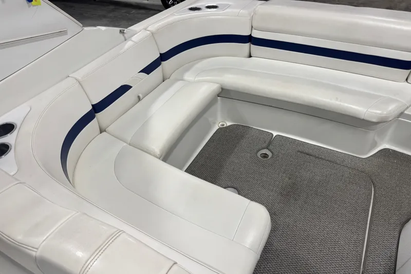 Slide: The Image of 2005 Formula 280 Bowrider interior with white and blue seating, cup holders, and carpeted floor. - 18