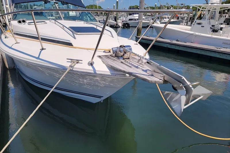 Slide: The Image of 1989 Sea Ray 270 Amberjack docked at marina, featuring anchor and bow railings. - 15