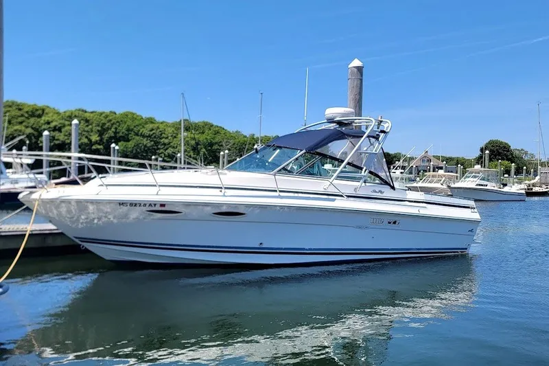 The Image of 1989 Sea Ray 270 Amberjack boat docked in a marina under clear blue skies. - 0