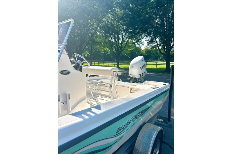 Slide: The Image of 2022 BLUEWAVE 2000 Classic boat with Suzuki outboard motor, parked outdoors. - 7