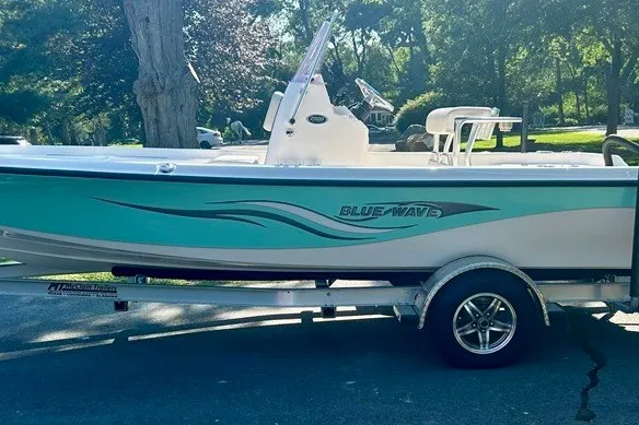 Slide: The Image of 2022 BLUEWAVE 2000 Classic boat on trailer, parked outdoors in a sunny setting. - 1