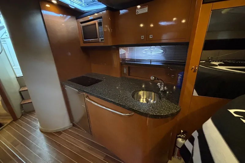 Slide: The Image of 2010 Chaparral Signature 370 yacht interior with modern kitchenette and sleek wood finish. - 29