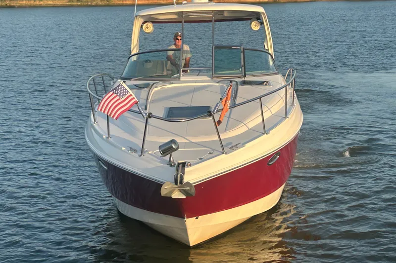 Slide: The Image of 2010 Chaparral Signature 370 boat cruising on a lake with an American flag. - 8