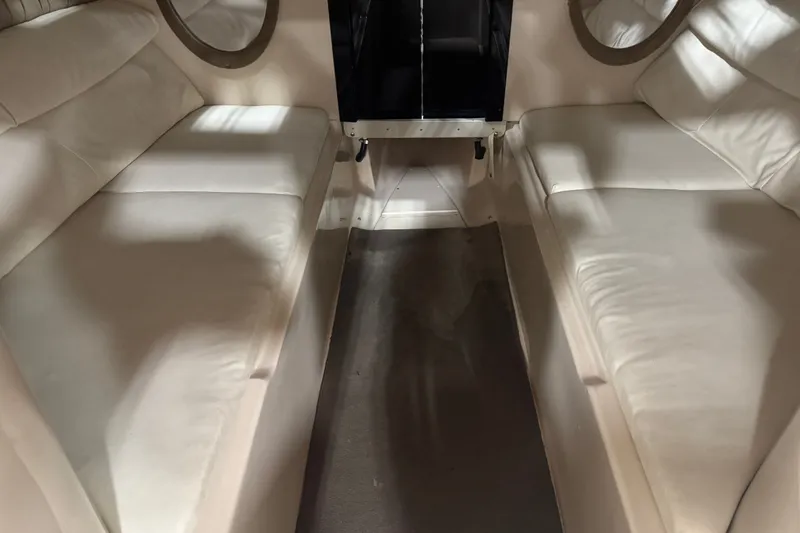 Slide: The Image of Interior of a 2000 Mariah 302 Shabah boat with white cushioned seating. - 10