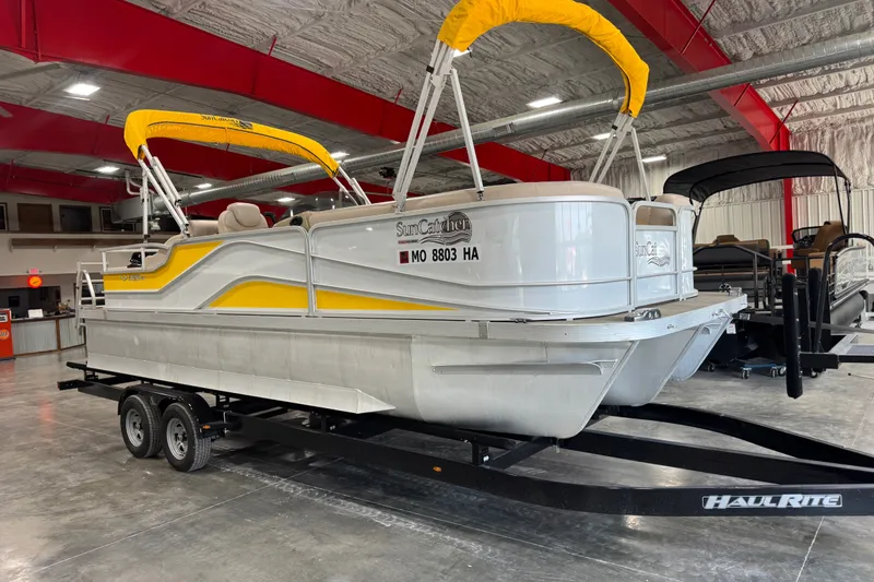 The Image of 2018 SunCatcher 322 VS pontoon boat with yellow canopy on HaulRite trailer in showroom. - 1