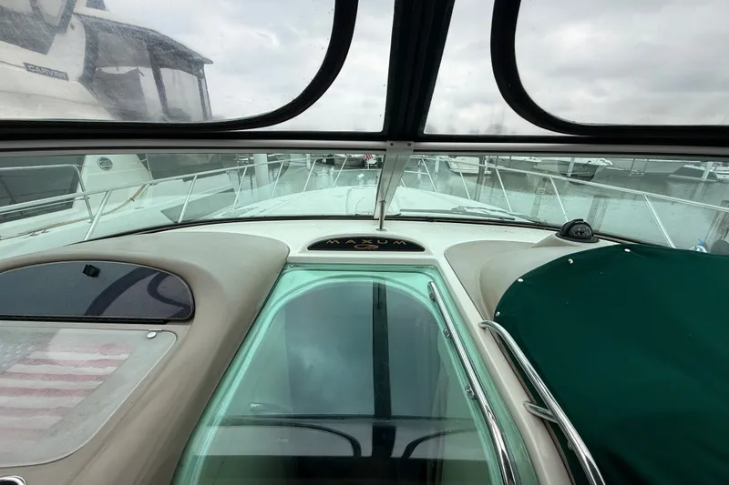 Slide: The Image of 2003 Maxum 3700 SCR yacht interior view with windshield and marina background. - 16