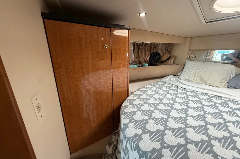 Slide: The Image of Cozy bedroom interior of 2003 Maxum 3700 SCR yacht with wooden cabinet and patterned bedding. - 42