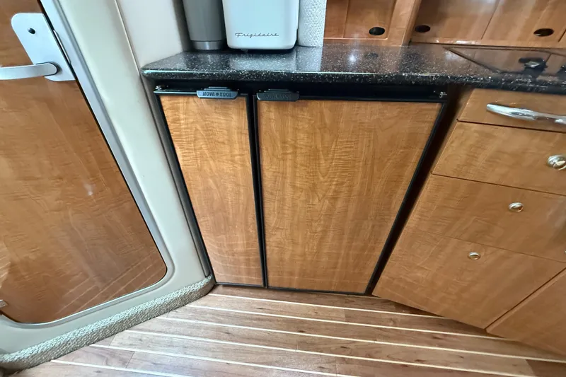 Slide: The Image of 2003 Maxum 3700 SCR yacht interior with wood-paneled fridge and sleek cabinetry. - 37