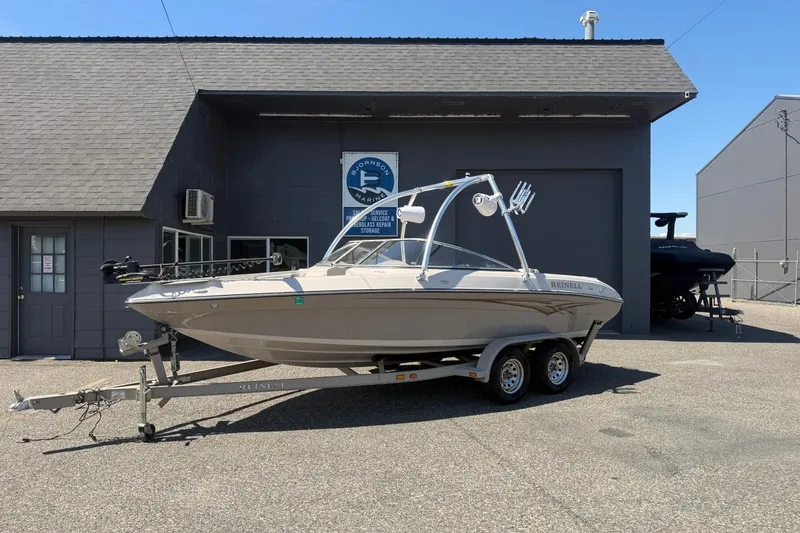 The Image of 2007 Reinell 204 Fish & Ski boat on trailer outside marine service building. - 0