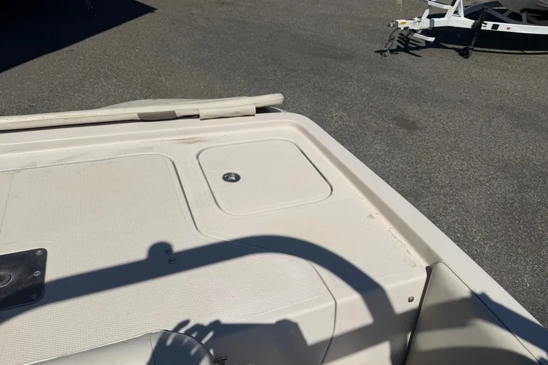 Slide: The Image of 2007 Reinell 204 Fish & Ski boat deck with storage compartment and trailer in background. - 41