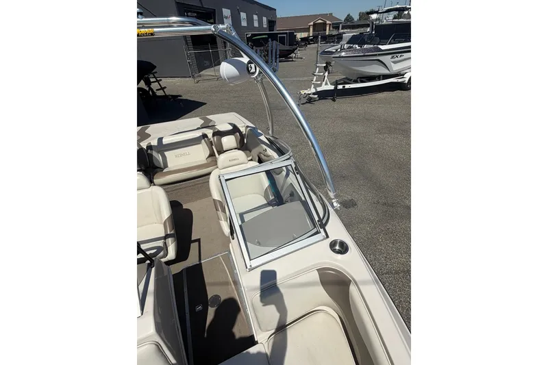 Slide: The Image of 2007 Reinell 204 Fish & Ski boat interior with seating and windshield, parked outdoors. - 31