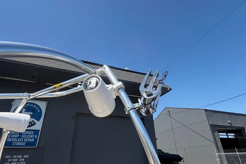 Slide: The Image of 2007 Reinell 204 Fish & Ski boat tower with speakers and wakeboard rack under clear blue sky. - 11