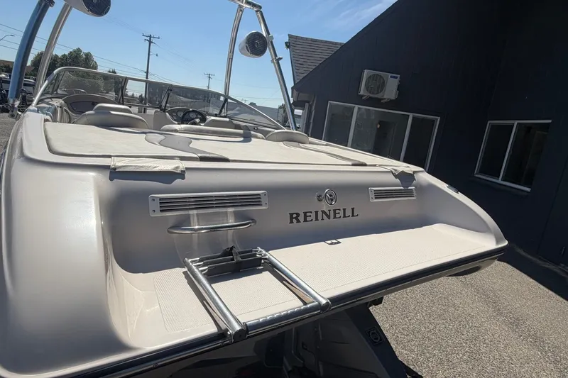 Slide: The Image of 2007 Reinell 204 Fish & Ski boat with swim platform and ladder, parked outdoors. - 12