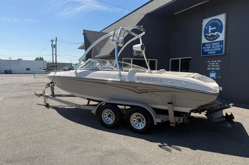 Slide: The Image of 2007 Reinell 204 Fish & Ski boat on trailer outside marine shop. - 2
