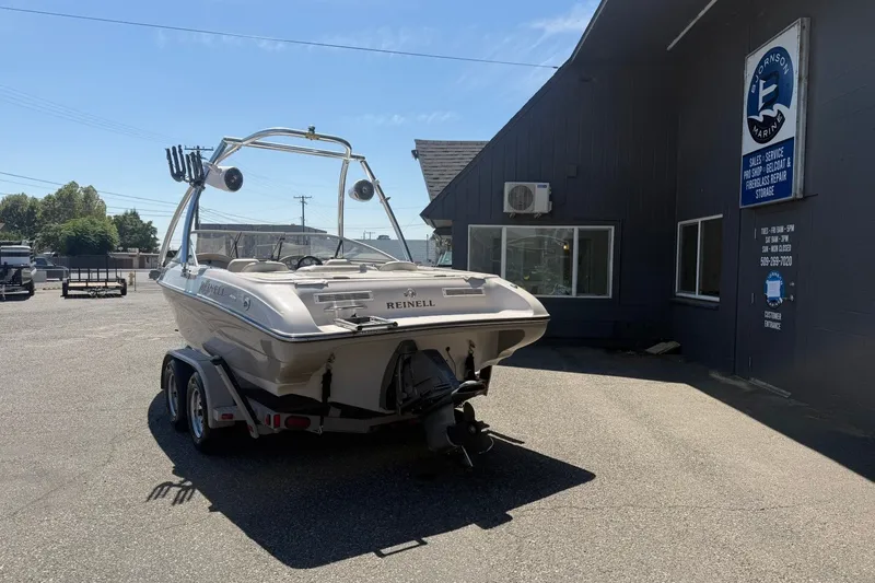 Slide: The Image of 2007 Reinell 204 Fish & Ski boat on trailer outside a marine service building. - 3