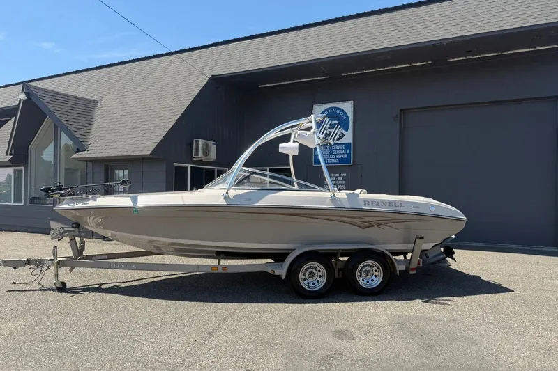 Slide: The Image of 2007 Reinell 204 Fish & Ski boat on trailer, parked outside a building. - 1