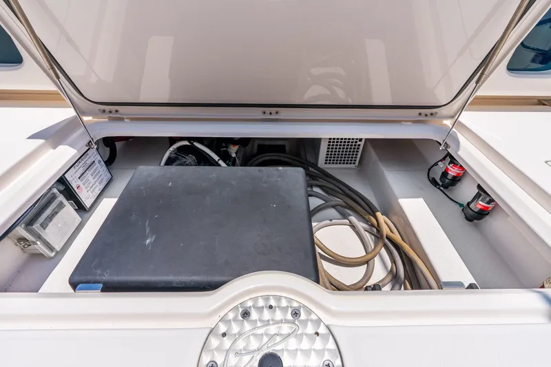 Slide: The Image of Open storage compartment on 2024 Solace 41CS boat, showing cables and equipment. - 33