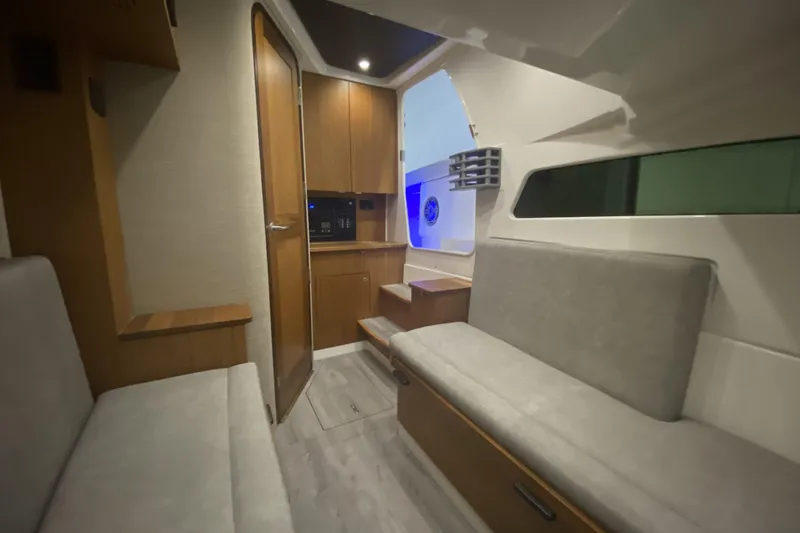 Slide: The Image of Manufacturer Provided Image: Interior of 2024 Solace 41 CS boat with modern seating and wooden cabinetry. - 44