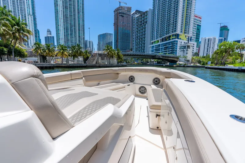 Slide: The Image of 2024 Solace 41CS boat cruising in a city waterway with skyscrapers and palm trees. - 34