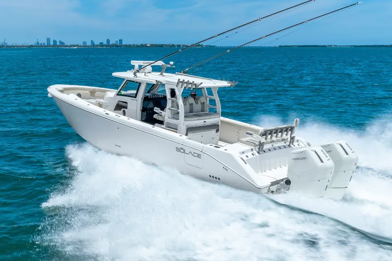 Slide: The Image of 2024 Solace 41CS boat cruising on blue ocean with city skyline in background. - 13