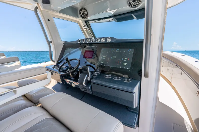 Slide: The Image of 2024 Solace 41CS boat cockpit with advanced navigation system and luxurious seating on open water. - 18