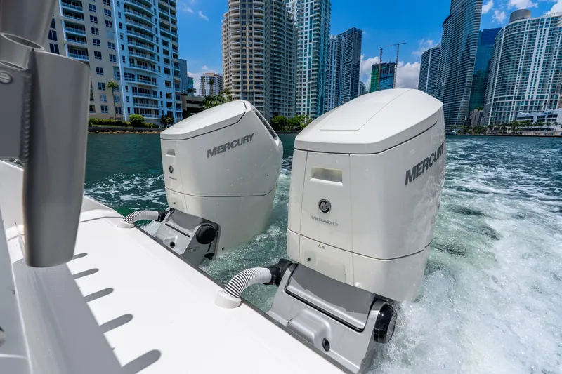 Slide: The Image of Twin Mercury outboard engines on a 2024 Solace 41CS boat cruising near city skyscrapers. - 51
