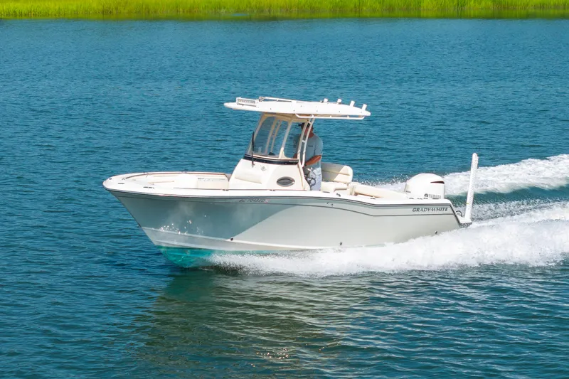 The Image of 2021 Grady-White Fisherman 236 cruising on blue water with green shoreline. - 0